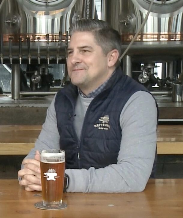 Brian Harzewski sitting at a table with a beer